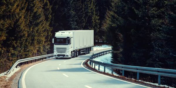 Klaviertransport Kleve: Lkw fährt auf einer kurvigen Straße durch den Wald