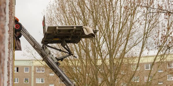 Möbellift zwischen kahlen Bäumen vor einem Gebäude – Möbellift in Kleve