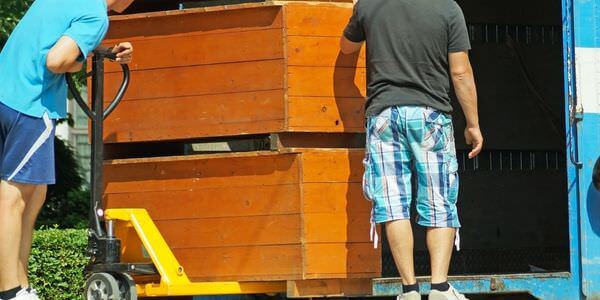 Möbellift Kleve: Zwei Helfer tragen einen Holzschrank aus einem Lkw