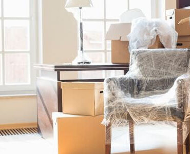 Umzugskartons Kleve Kartons zwischen Sesseln in einem hellen Zimmer – Umzugskartons Kleve